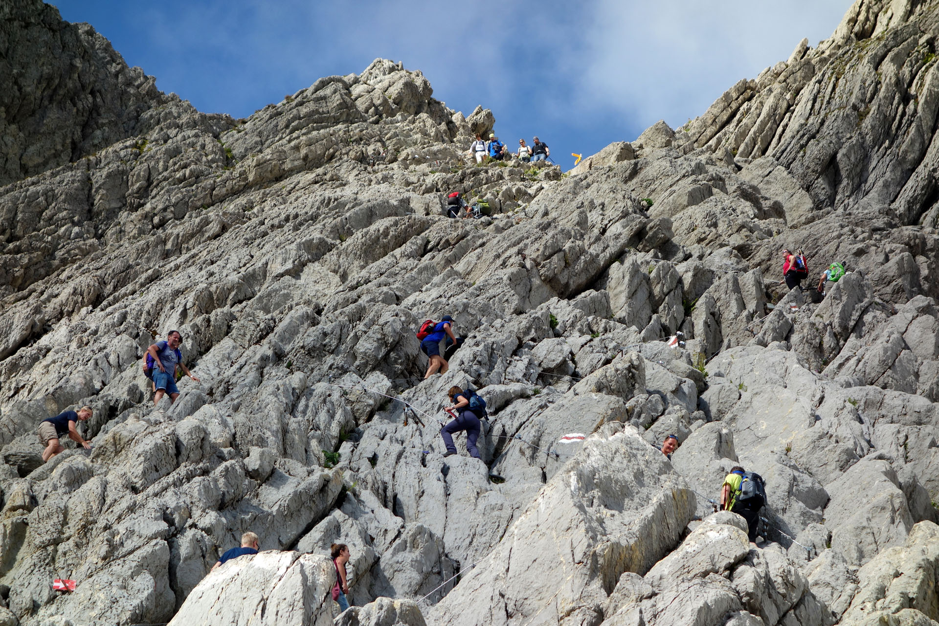 Bergweg durch Fels mit vielen Wanderern