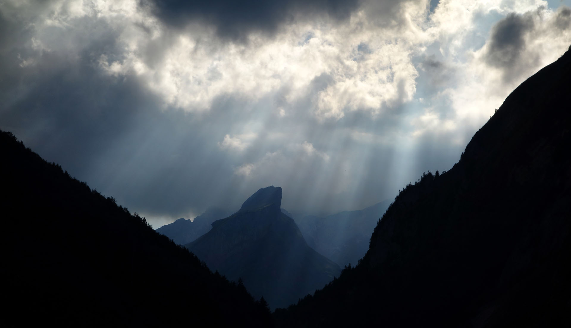 Dunkle Berge mit Sonnenstrahlen