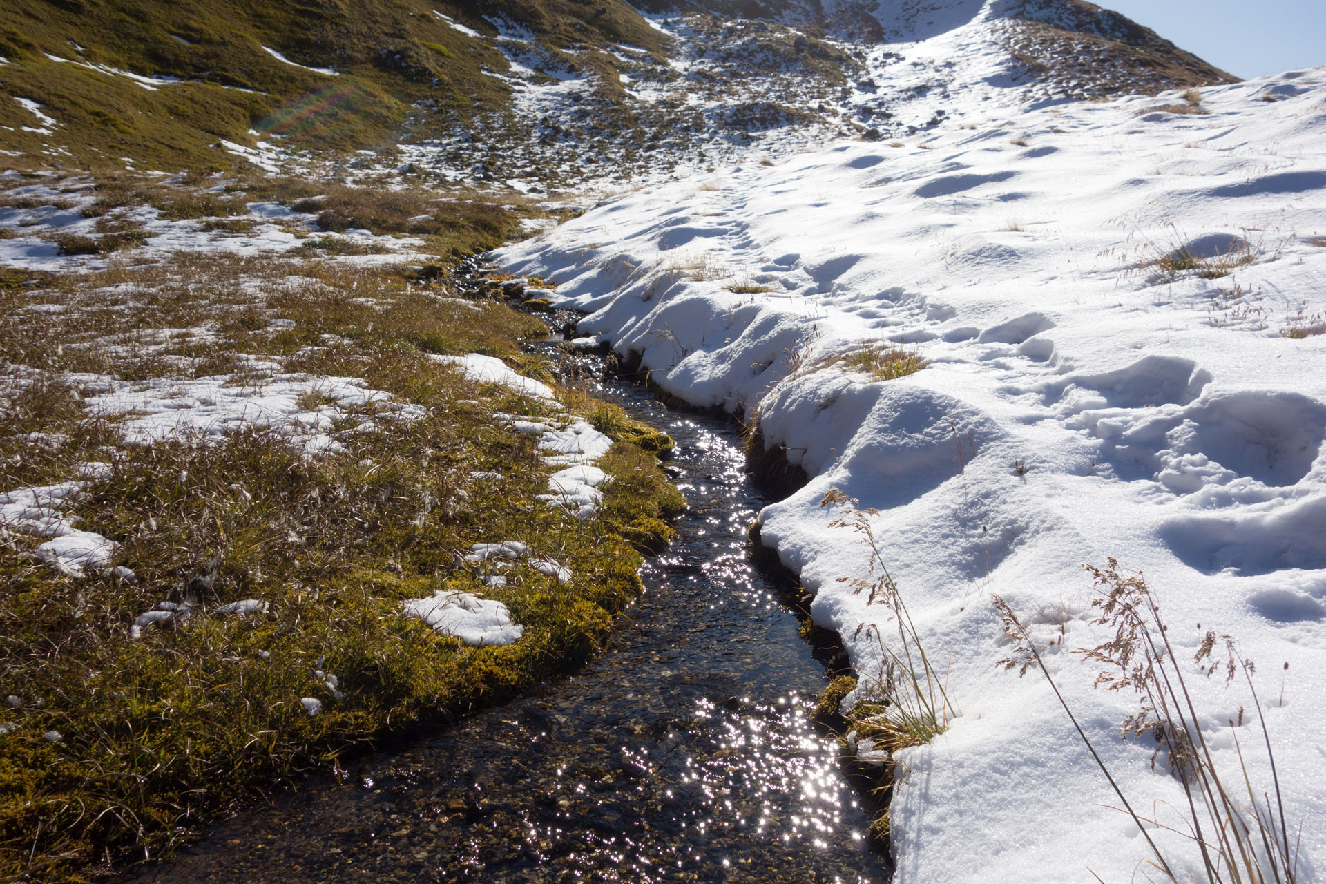 Pfad durch Schnee an Bach