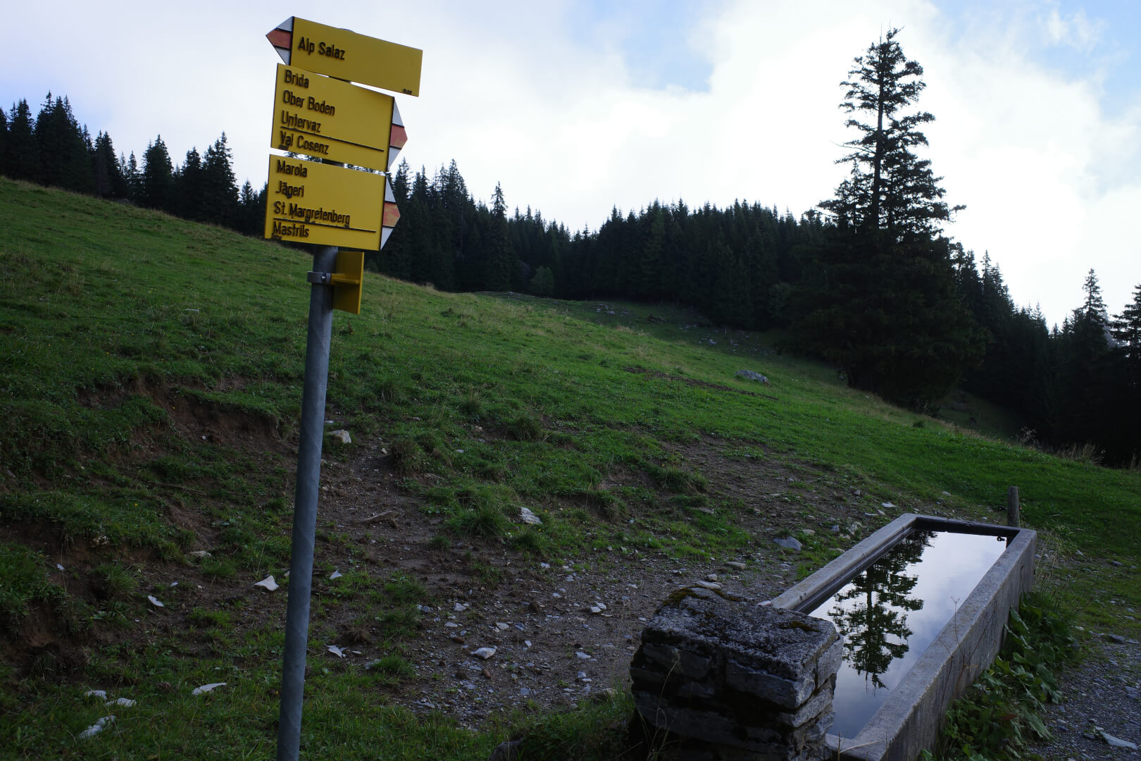 Wegweiser und Brunnen